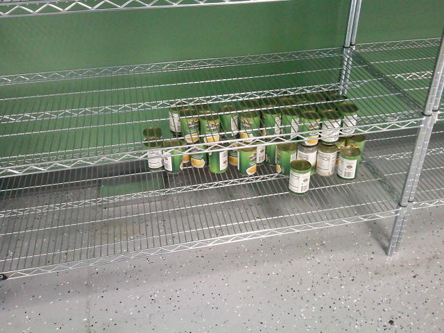Canned apple on the bottom of a shelf.